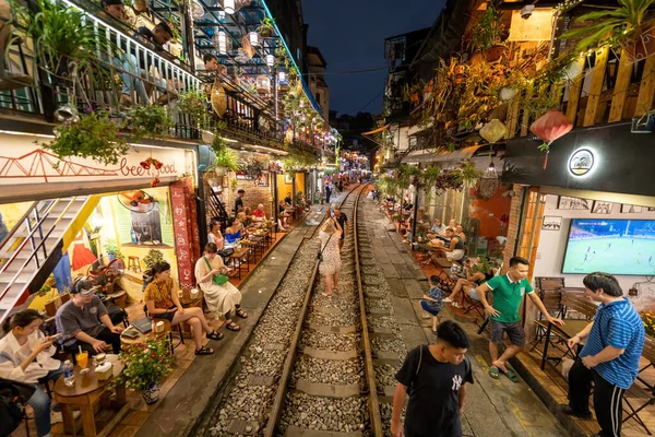 Hanoi, Vietnam - 08 Mayıs 2023: Hanoi Eski Mahallesi 'nin dar bir sokağından geçen tren görüntüsü. Turistler trenin resimlerini çekiyorlar. Hanoi Tren Sokağı popüler bir eğlencedir..