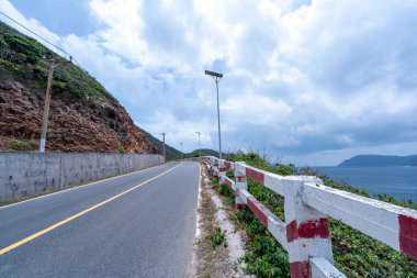 Vietnam 'da barış dolu bir Con Dao adası Vietnam' ın cennet adasıdır. Dalgalı kıyı manzarası, kıyı şeridi, açık gökyüzü ve yol, mavi deniz, turistler ve dağ. Seyahat ve manzara konsepti.