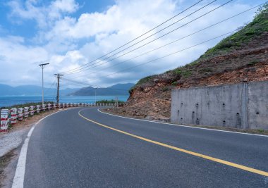 Vietnam 'da barış dolu bir Con Dao adası Vietnam' ın cennet adasıdır. Dalgalı kıyı manzarası, kıyı şeridi, açık gökyüzü ve yol, mavi deniz, turistler ve dağ. Seyahat ve manzara konsepti.
