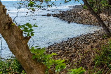 Vietnam 'da barış dolu bir Con Dao adası Vietnam' ın cennet adasıdır. Dalgalı kıyı manzarası, kıyı şeridi, açık gökyüzü ve yol, mavi deniz, turistler ve dağ. Seyahat ve manzara konsepti.