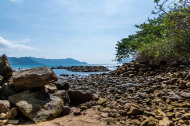 Vietnam 'da barış dolu bir Con Dao adası Vietnam' ın cennet adasıdır. Dalgalı kıyı manzarası, kıyı şeridi, açık gökyüzü ve yol, mavi deniz, turistler ve dağ. Seyahat ve manzara konsepti.