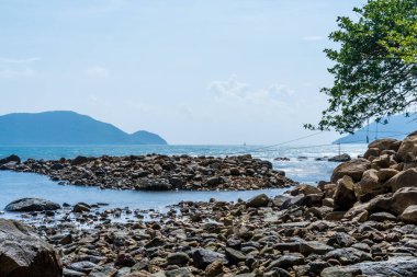 Vietnam 'da barış dolu bir Con Dao adası Vietnam' ın cennet adasıdır. Dalgalı kıyı manzarası, kıyı şeridi, açık gökyüzü ve yol, mavi deniz, turistler ve dağ. Seyahat ve manzara konsepti.