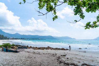 Vietnam 'da barış dolu bir Con Dao adası Vietnam' ın cennet adasıdır. Dalgalı kıyı manzarası, kıyı şeridi, açık gökyüzü ve yol, mavi deniz, turistler ve dağ. Seyahat ve manzara konsepti.