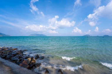 Vietnam 'da barış dolu bir Con Dao adası Vietnam' ın cennet adasıdır. Dalgalı kıyı manzarası, kıyı şeridi, açık gökyüzü ve yol, mavi deniz, turistler ve dağ. Seyahat ve manzara konsepti.