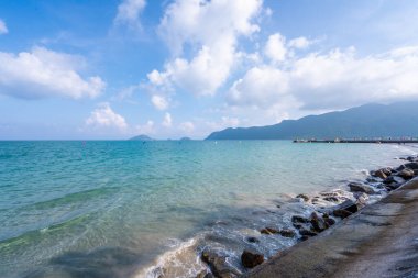 Vietnam 'da barış dolu bir Con Dao adası Vietnam' ın cennet adasıdır. Dalgalı kıyı manzarası, kıyı şeridi, açık gökyüzü ve yol, mavi deniz, turistler ve dağ. Seyahat ve manzara konsepti.