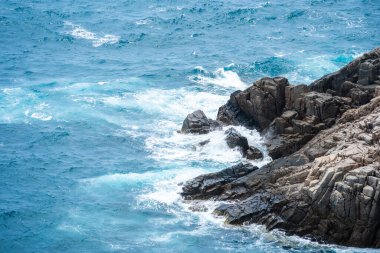 Dalgalar sahildeki kayaları vurur, deniz suyu gökyüzüne güneş ile vurur. Vietnam 'da barış dolu bir Con Dao adası Vietnam' ın cennet adasıdır. Seyahat ve manzara konsepti.