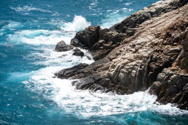 Dalgalar sahildeki kayaları vurur, deniz suyu gökyüzüne güneş ile vurur. Vietnam 'da barış dolu bir Con Dao adası Vietnam' ın cennet adasıdır. Seyahat ve manzara konsepti.