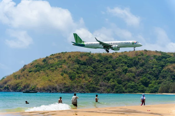 stock image Con Dao island, Vietnam - 01 May 2023: View of beautiful Dam Trau beach in Con Dao island, Vietnam with airplane is landing. Coastal view with waves, coastline, blue sky and mountain.