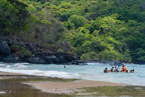 Con Dao Adası, Vietnam - 01 Mayıs 2023: Con Dao Adası, Vietnam 'daki Güzel Baraj Trau Sahili. Dalgalı kıyı manzarası, açık gökyüzü ve yol, mavi deniz, turistler ve dağ.