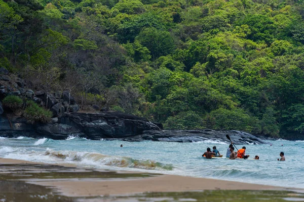 Con Dao Adası, Vietnam - 01 Mayıs 2023: Con Dao Adası, Vietnam 'daki Güzel Baraj Trau Sahili. Dalgalı kıyı manzarası, açık gökyüzü ve yol, mavi deniz, turistler ve dağ.