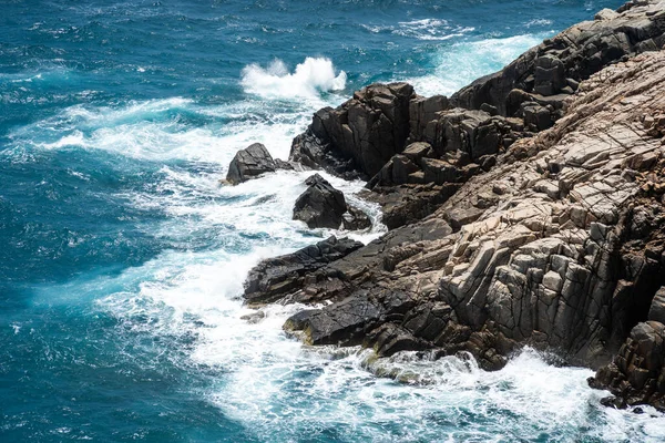 Dalgalar sahildeki kayaları vurur, deniz suyu gökyüzüne güneş ile vurur. Vietnam 'da barış dolu bir Con Dao adası Vietnam' ın cennet adasıdır. Seyahat ve manzara konsepti.