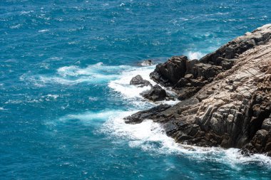 Dalgalar sahildeki kayaları vurur, deniz suyu gökyüzüne güneş ile vurur. Vietnam 'da barış dolu bir Con Dao adası Vietnam' ın cennet adasıdır. Seyahat ve manzara konsepti.