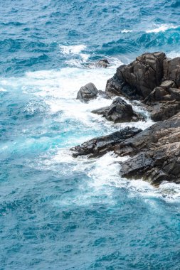 Dalgalar sahildeki kayaları vurur, deniz suyu gökyüzüne güneş ile vurur. Vietnam 'da barış dolu bir Con Dao adası Vietnam' ın cennet adasıdır. Seyahat ve manzara konsepti.