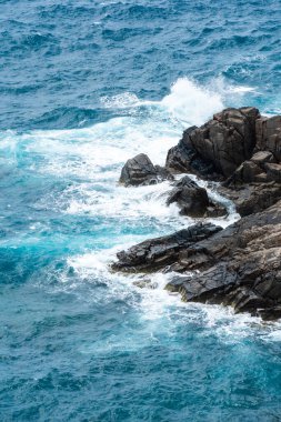 Dalgalar sahildeki kayaları vurur, deniz suyu gökyüzüne güneş ile vurur. Vietnam 'da barış dolu bir Con Dao adası Vietnam' ın cennet adasıdır. Seyahat ve manzara konsepti.