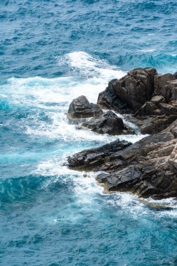 Dalgalar sahildeki kayaları vurur, deniz suyu gökyüzüne güneş ile vurur. Vietnam 'da barış dolu bir Con Dao adası Vietnam' ın cennet adasıdır. Seyahat ve manzara konsepti.