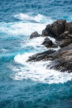 Dalgalar sahildeki kayaları vurur, deniz suyu gökyüzüne güneş ile vurur. Vietnam 'da barış dolu bir Con Dao adası Vietnam' ın cennet adasıdır. Seyahat ve manzara konsepti.