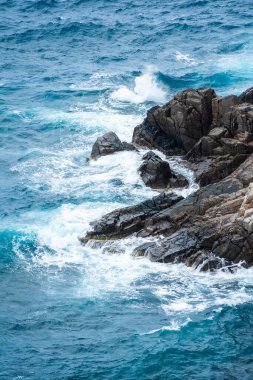 Dalgalar sahildeki kayaları vurur, deniz suyu gökyüzüne güneş ile vurur. Vietnam 'da barış dolu bir Con Dao adası Vietnam' ın cennet adasıdır. Seyahat ve manzara konsepti.