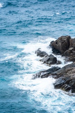 Dalgalar sahildeki kayaları vurur, deniz suyu gökyüzüne güneş ile vurur. Vietnam 'da barış dolu bir Con Dao adası Vietnam' ın cennet adasıdır. Seyahat ve manzara konsepti.