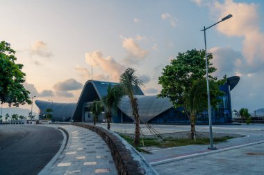 Con Son kasabasındaki yeni Con Dao yolcu limanının manzarası. Huzurlu bir Con Dao Adası, Vietnam. Dalgalı kıyı manzarası, kıyı şeridi, açık gökyüzü, mavi deniz, turistler ve dağ. Seyahat ve manzara konsepti.