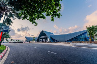 Con Son kasabasındaki yeni Con Dao yolcu limanının manzarası. Huzurlu bir Con Dao Adası, Vietnam. Dalgalı kıyı manzarası, kıyı şeridi, açık gökyüzü, mavi deniz, turistler ve dağ. Seyahat ve manzara konsepti.