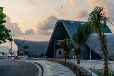 Con Son kasabasındaki yeni Con Dao yolcu limanının manzarası. Huzurlu bir Con Dao Adası, Vietnam. Dalgalı kıyı manzarası, kıyı şeridi, açık gökyüzü, mavi deniz, turistler ve dağ. Seyahat ve manzara konsepti.