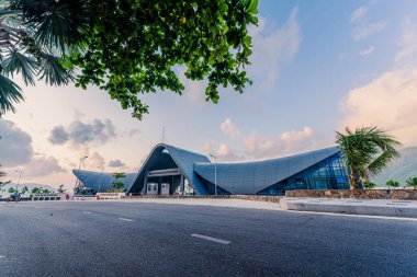 Con Son kasabasındaki yeni Con Dao yolcu limanının manzarası. Huzurlu bir Con Dao Adası, Vietnam. Dalgalı kıyı manzarası, kıyı şeridi, açık gökyüzü, mavi deniz, turistler ve dağ. Seyahat ve manzara konsepti.
