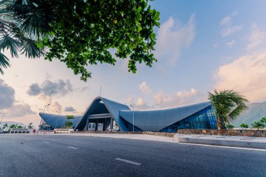 Con Son kasabasındaki yeni Con Dao yolcu limanının manzarası. Huzurlu bir Con Dao Adası, Vietnam. Dalgalı kıyı manzarası, kıyı şeridi, açık gökyüzü, mavi deniz, turistler ve dağ. Seyahat ve manzara konsepti.