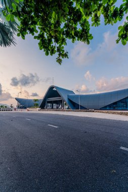 Con Son kasabasındaki yeni Con Dao yolcu limanının manzarası. Huzurlu bir Con Dao Adası, Vietnam. Dalgalı kıyı manzarası, kıyı şeridi, açık gökyüzü, mavi deniz, turistler ve dağ. Seyahat ve manzara konsepti.