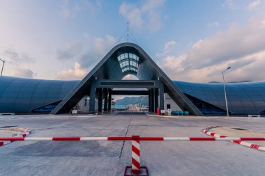 Con Son kasabasındaki yeni Con Dao yolcu limanının manzarası. Huzurlu bir Con Dao Adası, Vietnam. Dalgalı kıyı manzarası, kıyı şeridi, açık gökyüzü, mavi deniz, turistler ve dağ. Seyahat ve manzara konsepti.