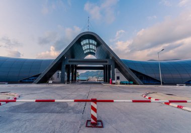Con Son kasabasındaki yeni Con Dao yolcu limanının manzarası. Huzurlu bir Con Dao Adası, Vietnam. Dalgalı kıyı manzarası, kıyı şeridi, açık gökyüzü, mavi deniz, turistler ve dağ. Seyahat ve manzara konsepti.