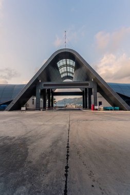 Con Son kasabasındaki yeni Con Dao yolcu limanının manzarası. Huzurlu bir Con Dao Adası, Vietnam. Dalgalı kıyı manzarası, kıyı şeridi, açık gökyüzü, mavi deniz, turistler ve dağ. Seyahat ve manzara konsepti.