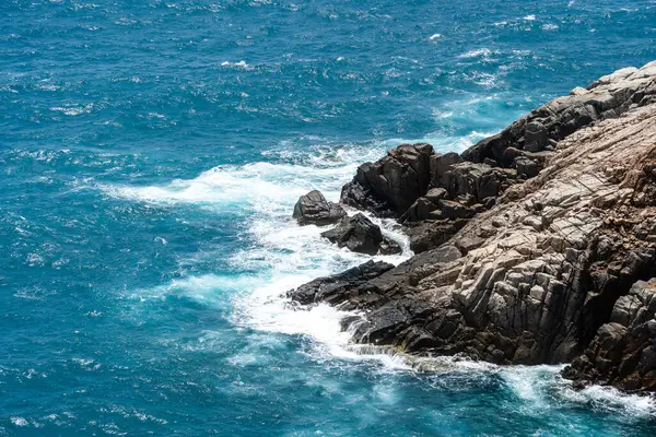 Dalgalar sahildeki kayaları vurur, deniz suyu gökyüzüne güneş ile vurur. Vietnam 'da barış dolu bir Con Dao adası Vietnam' ın cennet adasıdır. Seyahat ve manzara konsepti.