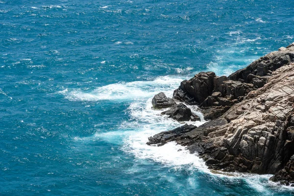 Dalgalar sahildeki kayaları vurur, deniz suyu gökyüzüne güneş ile vurur. Vietnam 'da barış dolu bir Con Dao adası Vietnam' ın cennet adasıdır. Seyahat ve manzara konsepti.