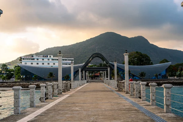 Con Son kasabasındaki yeni Con Dao yolcu limanının manzarası. Huzurlu bir Con Dao Adası, Vietnam. Dalgalı kıyı manzarası, kıyı şeridi, açık gökyüzü, mavi deniz, turistler ve dağ. Seyahat ve manzara konsepti.
