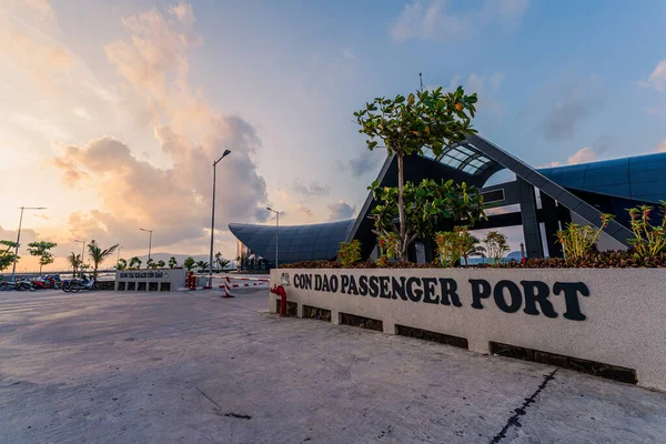 Con Son kasabasındaki yeni Con Dao yolcu limanının manzarası. Huzurlu bir Con Dao Adası, Vietnam. Dalgalı kıyı manzarası, kıyı şeridi, açık gökyüzü, mavi deniz, turistler ve dağ. Seyahat ve manzara konsepti.