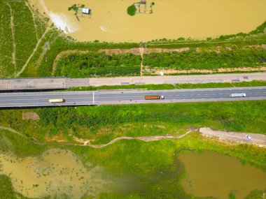 Dong Nai vilayetindeki Ulusal Yol 20 'nin havadan görüntüsü La Nga nehri üzerinde yüzen bir grup ev tepe manzaralı ve yol çevresindeki seyrek nüfuslu. Seyahat ve manzara konsepti.