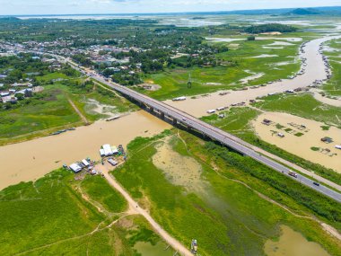 Dong Nai vilayetindeki Ulusal Yol 20 'nin havadan görüntüsü La Nga nehri üzerinde yüzen bir grup ev tepe manzaralı ve yol çevresindeki seyrek nüfuslu. Seyahat ve manzara konsepti.