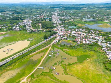 Dong Nai vilayetindeki Ulusal Yol 20 'nin havadan görüntüsü La Nga nehri üzerinde yüzen bir grup ev tepe manzaralı ve yol çevresindeki seyrek nüfuslu. Seyahat ve manzara konsepti.