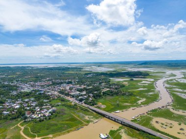 Dong Nai vilayetindeki Ulusal Yol 20 'nin havadan görüntüsü La Nga nehri üzerinde yüzen bir grup ev tepe manzaralı ve yol çevresindeki seyrek nüfuslu. Seyahat ve manzara konsepti.