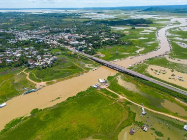 Dong Nai vilayetindeki Ulusal Yol 20 'nin havadan görüntüsü La Nga nehri üzerinde yüzen bir grup ev tepe manzaralı ve yol çevresindeki seyrek nüfuslu. Seyahat ve manzara konsepti.