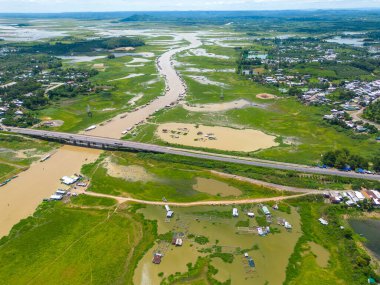Dong Nai vilayetindeki Ulusal Yol 20 'nin havadan görüntüsü La Nga nehri üzerinde yüzen bir grup ev tepe manzaralı ve yol çevresindeki seyrek nüfuslu. Seyahat ve manzara konsepti.