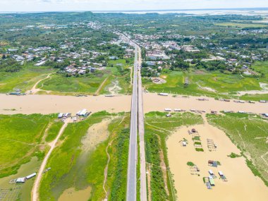 Dong Nai vilayetindeki Ulusal Yol 20 'nin havadan görüntüsü La Nga nehri üzerinde yüzen bir grup ev tepe manzaralı ve yol çevresindeki seyrek nüfuslu. Seyahat ve manzara konsepti.