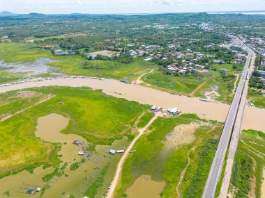 Dong Nai vilayetindeki Ulusal Yol 20 'nin havadan görüntüsü La Nga nehri üzerinde yüzen bir grup ev tepe manzaralı ve yol çevresindeki seyrek nüfuslu. Seyahat ve manzara konsepti.