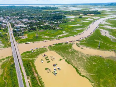 Dong Nai vilayetindeki Ulusal Yol 20 'nin havadan görüntüsü La Nga nehri üzerinde yüzen bir grup ev tepe manzaralı ve yol çevresindeki seyrek nüfuslu. Seyahat ve manzara konsepti.