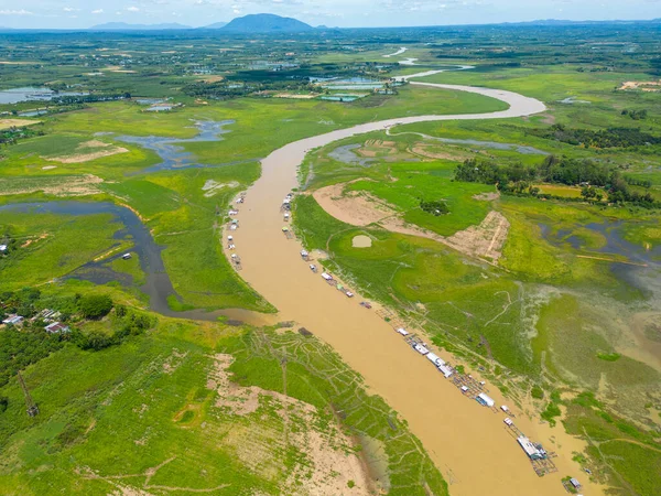 Dong Nai vilayetindeki Ulusal Yol 20 'nin havadan görüntüsü La Nga nehri üzerinde yüzen bir grup ev tepe manzaralı ve yol çevresindeki seyrek nüfuslu. Seyahat ve manzara konsepti.