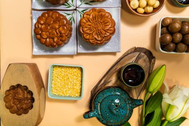 Sonbahar festivalinde leziz yuvarlak ay pastaları. Sonbahar festivalinin ortasında tatlı bej arka planda yiyecek ve içecekler yatıyordu. Seyahat, tatil, yemek konsepti