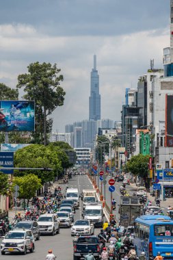 Ho Chi Minh şehri, Vietnam - 12 Ağustos 2023: Güneşli bir günde yoğun trafik ve Saygon caddesinde sayısız otel, bar ve dükkan tabelası bulunan renkli perspektif, insanlarla dolu, motosikletler