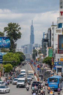 Ho Chi Minh şehri, Vietnam - 12 Ağustos 2023: Güneşli bir günde yoğun trafik ve Saygon caddesinde sayısız otel, bar ve dükkan tabelası bulunan renkli perspektif, insanlarla dolu, motosikletler