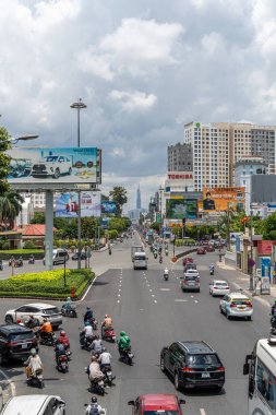 Ho Chi Minh şehri, Vietnam - 12 Ağustos 2023: Güneşli bir günde yoğun trafik ve Saygon caddesinde sayısız otel, bar ve dükkan tabelası bulunan renkli perspektif, insanlarla dolu, motosikletler