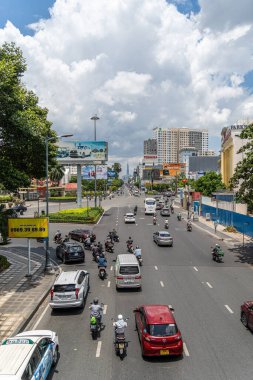 Ho Chi Minh şehri, Vietnam - 12 Ağustos 2023: Güneşli bir günde yoğun trafik ve Saygon caddesinde sayısız otel, bar ve dükkan tabelası bulunan renkli perspektif, insanlarla dolu, motosikletler